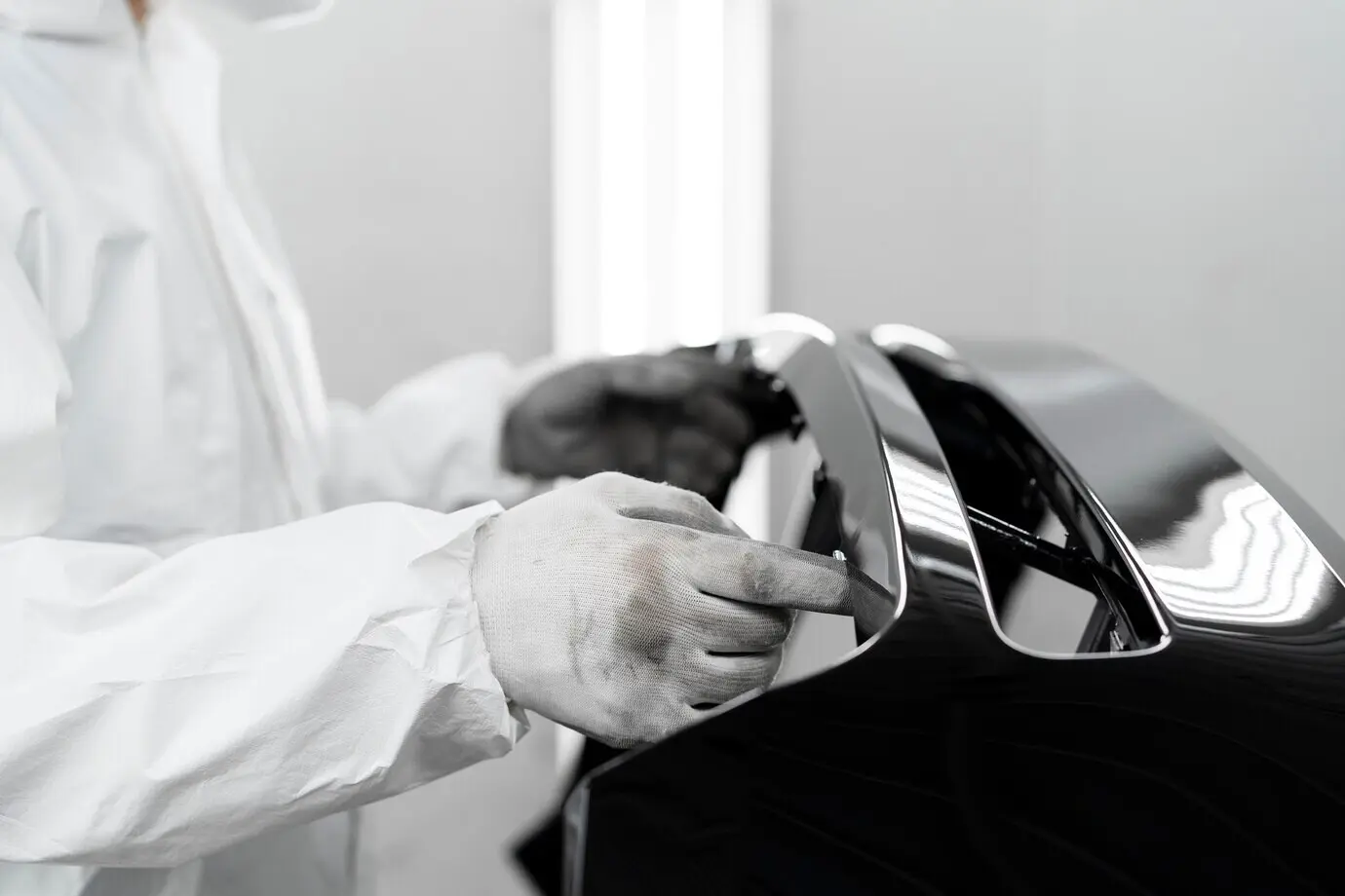 Männlicher Maler in einem Gefahrstoffschutzanzug in einer Autowerkstatt